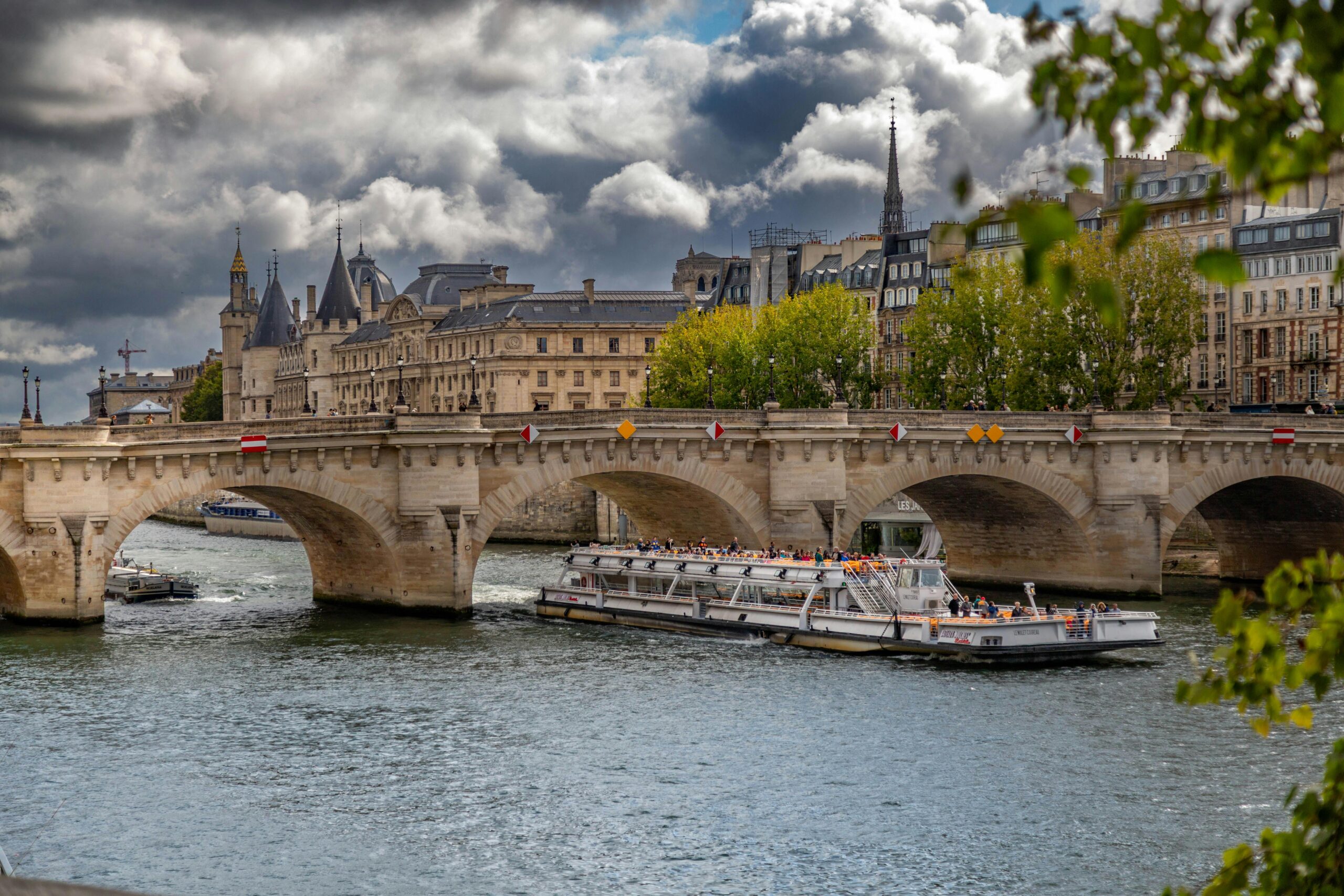 Scenic view of the historic Pont Neuf and a cruise boat on the Seine in Paris.
